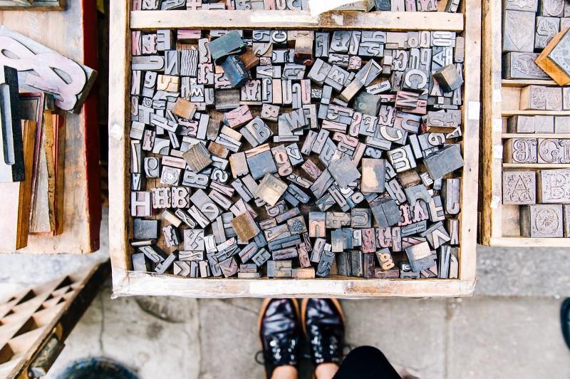 Container of printing press block letters of various sizes and font families.