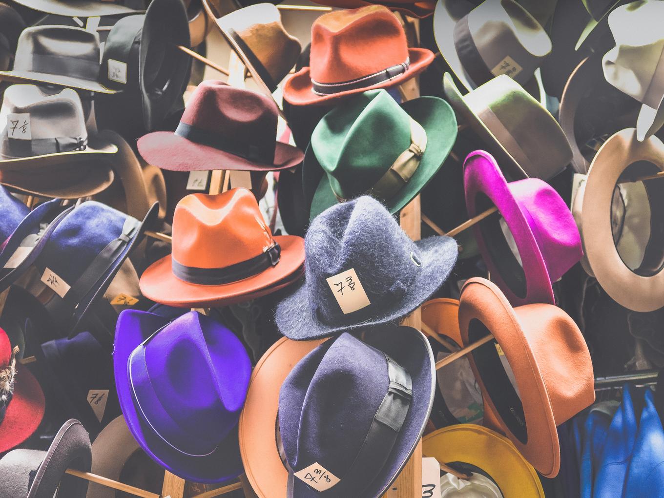 A group of multi-colored hats in a pile.